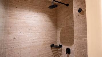 Ein Badezimmer mit Dusche, Handtuchhalter und einer Wandleuchte.