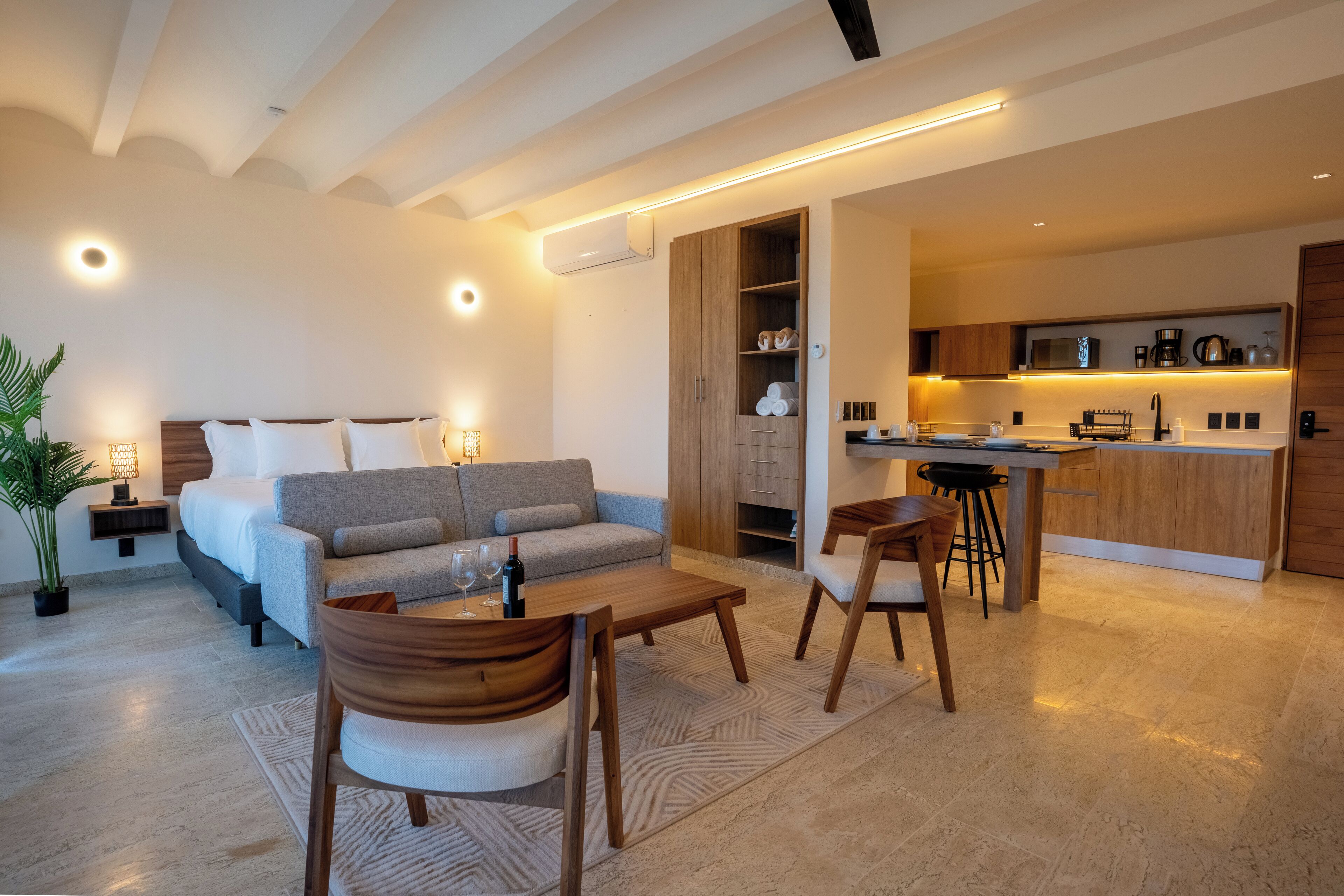 A modern, open-plan living area with a sofa, dining table, and kitchen.