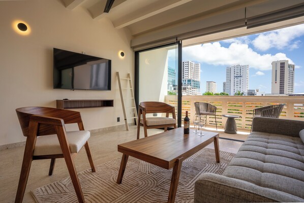 Suite estudio empresarial, balcón, vista a la ciudad | Área de sala de estar