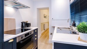 A modern kitchen with a built-in oven, a coffee maker, and a sink. - Stylish 1-Bed Flat | York Centre | Sleeps 4 (York)