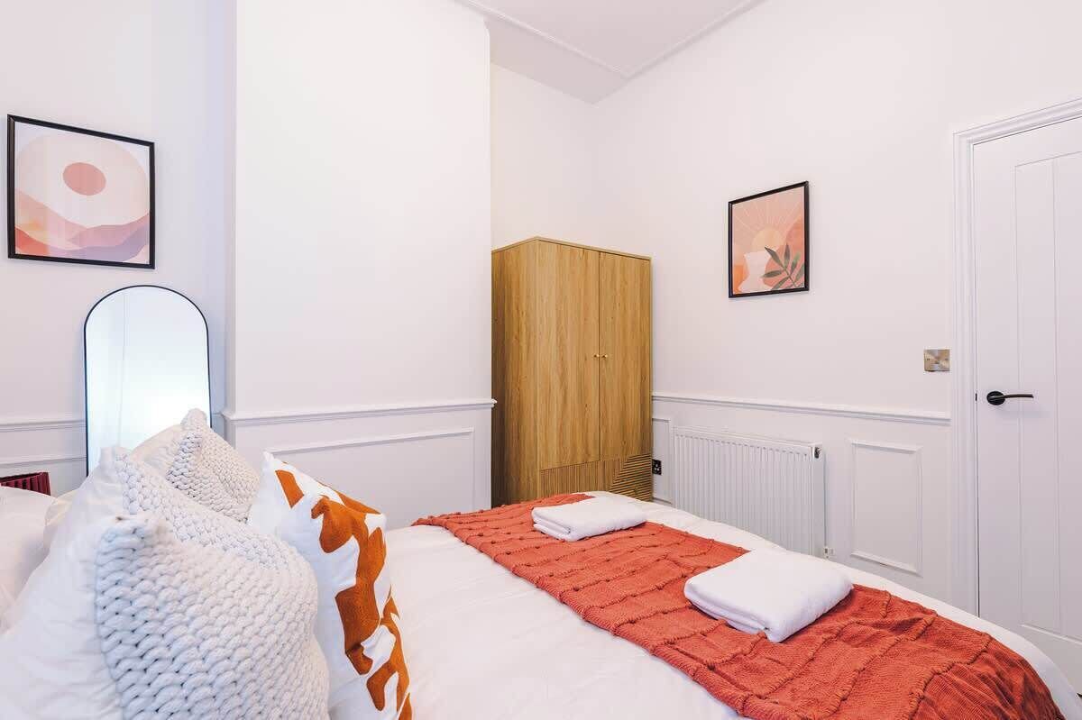 Un dormitorio con una cama, un armario de madera y una puerta blanca.
