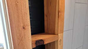 A wooden structure with a black panel, likely part of a building's interior. - Tiny Tiger Shipping container with AC in charming Whitney (Whitney)