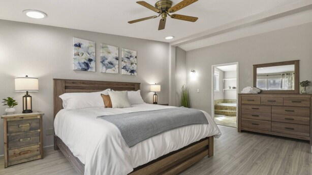 A bedroom with a wooden bed, a ceiling fan, a dresser, and a mirror. - Family-Friendly Mtn Retreat |Fireplace•Pets•Trails (Florissant)