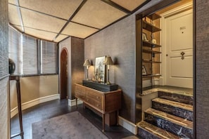 A hallway with a wooden bench, a door labeled '501', and a staircase with marble steps. - TB Place Roma (Rome)