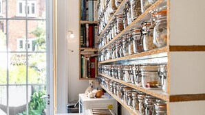 A kitchen with shelves of jars and a window with a view of greenery. - Listed Georgian Home w/ Contemporary Architecture (London)