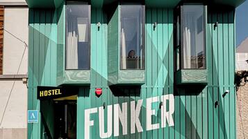 Un hostal con fachada verde y la palabra 'FUNKER' destacada.