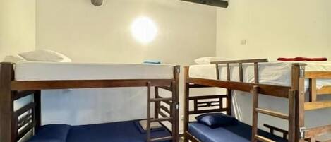 A room with bunk beds, a tiled floor, and a visible ceiling beam.