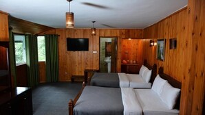 A wooden-paneled room with two beds, a flat-screen TV, and a ceiling fan. - Jaithra Inn (Nuwara Eliya)