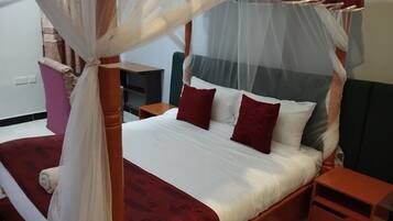 A four-poster bed with a canopy, two bedside tables, and a nightstand.