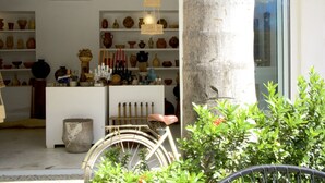 Una habitación con estanterías llenas de cerámica y una bicicleta al frente.