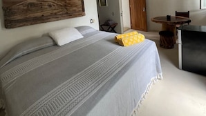 Une chambre à coucher avec un grand lit, une tête de lit en bois, une petite table et une chaise.