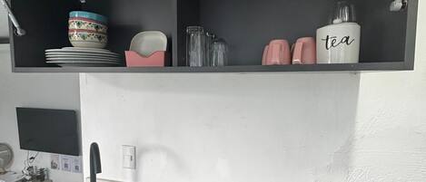 Une cuisine avec un évier noir, une cuisinière et un plan de travail.