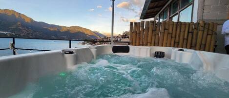 Un jacuzzi con vista a montañas y un cuerpo de agua.
