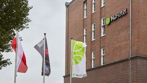 A brick building with the H+Hotel logo. - H+ Hotel Lübeck (Lubeck)