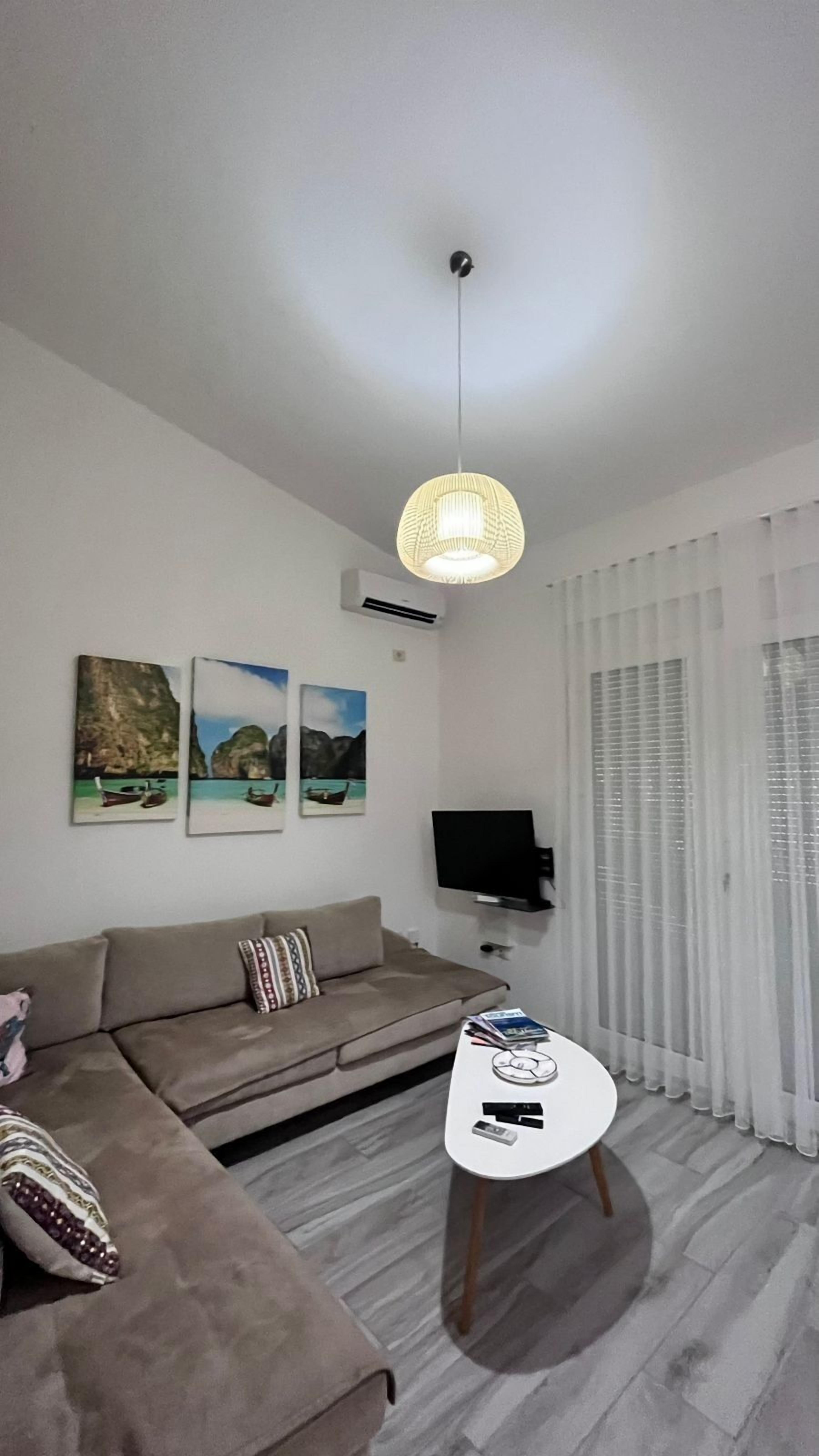 Una sala de estar moderna con sofá, una mesa de centro y obras de arte en la pared.
