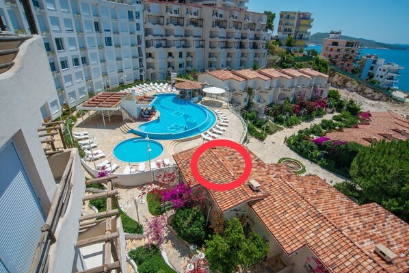 Un resort con varias piscinas, un jardín ajardinado y vistas al mar.