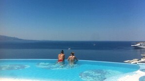 An infinity pool with a view of the ocean and a yacht in the background. - Family Seaview Condo Bougainville Bay (Sarande)