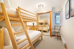 Um quarto com uma cama beliche, uma escrivaninha e uma cadeira.