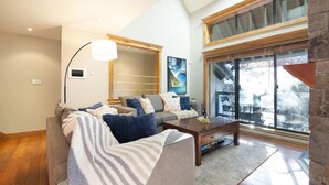 Ein modernes Wohnzimmer mit einer Couch, einem Couchtisch und einem großen Fenster mit Blick.