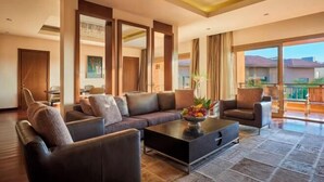 A modern living room with a sofa set, a coffee table, and a view of the outdoors. - Dusit Thani LakeView Cairo (New Cairo City)