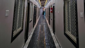 A hallway with a modern ceiling design, metal grilles on the walls, and a reflective floor. - Srikhetra Palace (Puri)