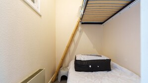A small, narrow room with a bunk bed, a white radiator, and a small stool. - Le Cocon du Chaud Costet - Avec balcon (Le Tholy)