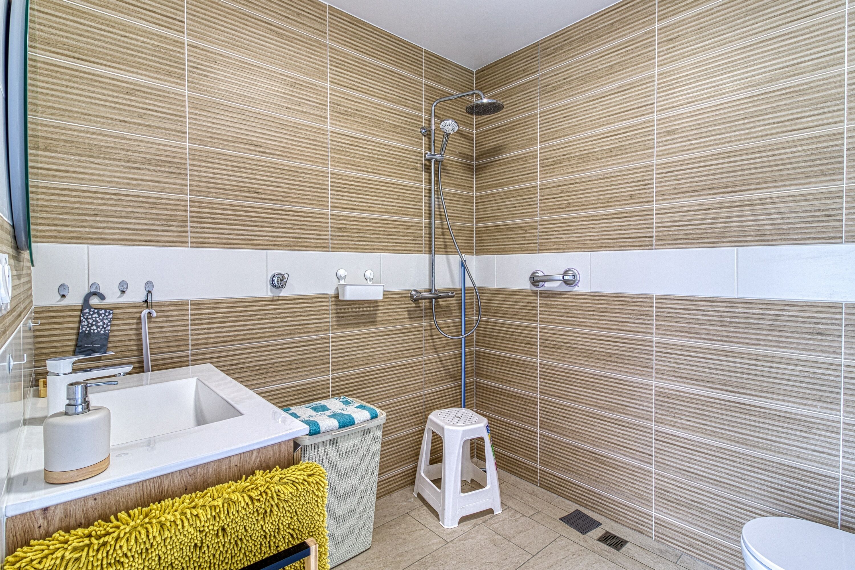 Une salle de bain moderne équipée d’une douche, d’un lavabo et de toilettes.