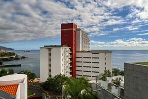 Un hôtel situé sur la côte, doté d’une tour rouge imposante, d’un port de plaisance et offrant une vue dégagée sur la mer.