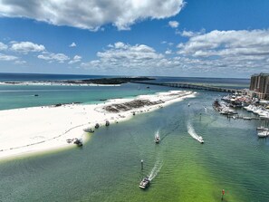 A coastal area with a sandy beach, marina, and a pier extending into the water.