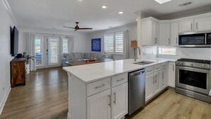 A modern kitchen with white cabinets, a stainless steel dishwasher, and a built-in oven. - Gulf Dreamin' - Waterfront, Destin Harbor, Private Dock, 2 Kings, New to VRBO! (Destin)