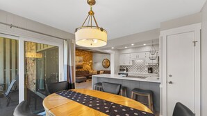 A modern kitchen with white cabinets, a central island, and a hanging light fixture. - Lc305ad2 (Dillon)