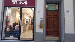 Un negozio TUMI con una porta in legno e un cartello che indica la vendita esclusiva di appartamenti.