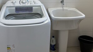 Un área de lavandería con lavadora y lavabo.