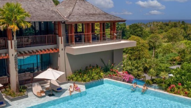 Un resort su due piani con piscina, posti a sedere all'aperto e vista sull'oceano.