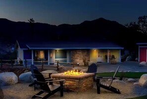 A modern house with a stone fireplace, outdoor seating, and a view of the mountains. - Beautiful Blossom Creek Suite (Three Rivers)