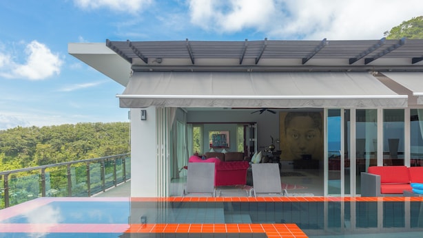 A modern house with a glass-enclosed balcony overlooking a lush green landscape. - The Villa In The Sky: Luxurious Abundance, Breathtaking Views, Premier Comfort (Kathu)