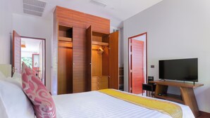 A hotel room with a bed, a TV, a wooden wardrobe, and a desk. - The Villa In The Sky: Luxurious Abundance, Breathtaking Views, Premier Comfort (Kathu)