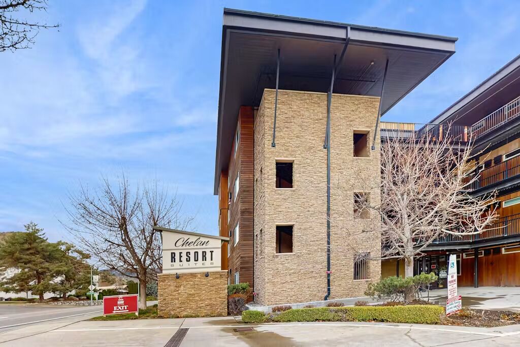 A Chelan Resort building with a modern architectural design, featuring a prominent entrance and a signboard.