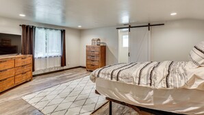 Un dormitorio con cama, cómoda de madera y armario.