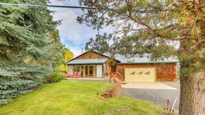 A two-story house with a garage, surrounded by a well-maintained lawn and trees. - Next to 600 Acres of Public Land! Bend Ranch Home (Bend)