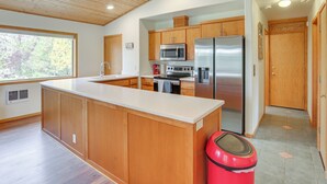 A modern kitchen with wooden cabinets, stainless steel appliances, and a large island. - Next to 600 Acres of Public Land! Bend Ranch Home (Bend)