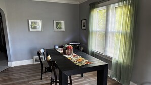A dining room with a long table, chairs, and a decorative runner. - Mid-Century Tudor in Quiet Detroit Neighborhood (Detroit)