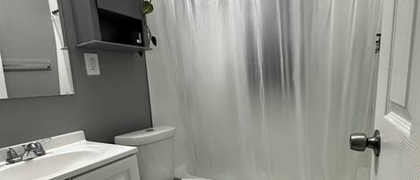 A bathroom with a toilet, sink, and bathtub.