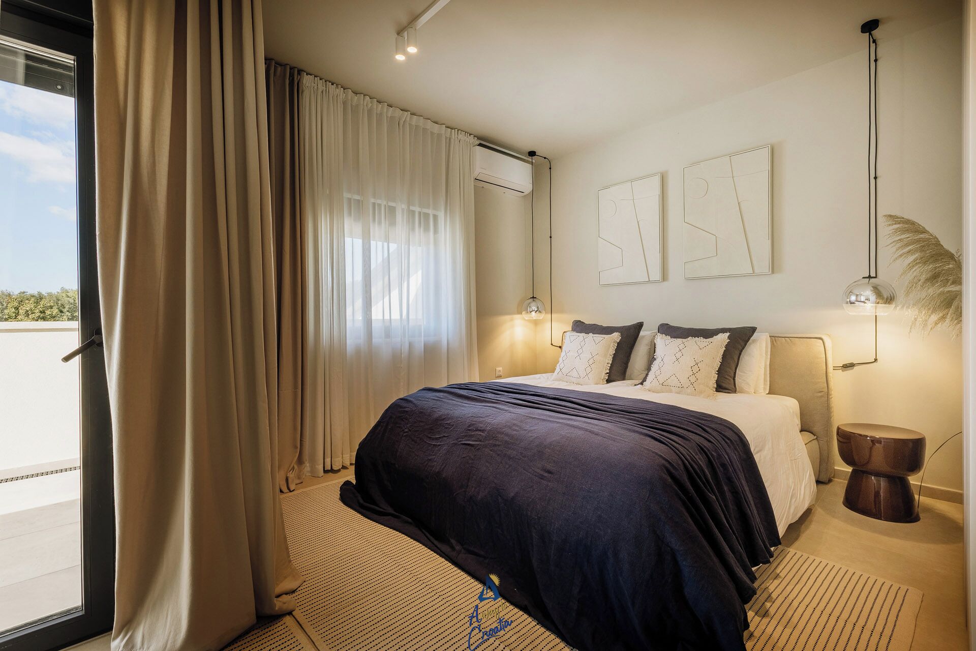 Una habitación de hotel moderna con una cama grande, vistas por la ventana y un ventilador de techo.