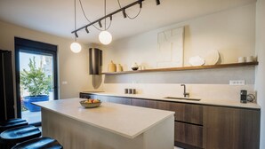 A modern kitchen with a central island, bar stools, a built-in oven, and a large window. - Charming New 3BR Villa for 6+2 with Private Pool (Višnjan)