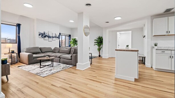Een modern appartement met een woonkamer, keuken en een eethoek.