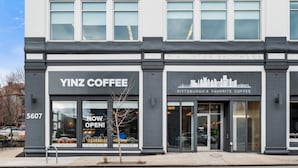 A building with two coffee shops, Yinz Coffee and Pittsburgh's Favorite Coffee, at 5607. - Cozy King Suite|Central, Workspace + Free Parking (Pittsburgh)
