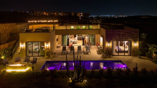 A modern hotel with a pool, outdoor seating, and a stone facade. - Escape to Cabo Luxury at Las Terrazas #05 (Cabo San Lucas)