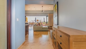 A spacious hallway with a wooden cabinet, a ceiling fan, and a view to a dining area with outdoor seating. - Escape to Cabo Luxury at Las Terrazas #05 (Cabo San Lucas)
