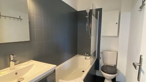 A modern bathroom with a bathtub, a sink, and a toilet.